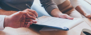couple signing paperwork with advisor