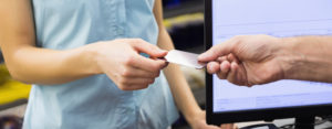 woman handing debit card to cashier